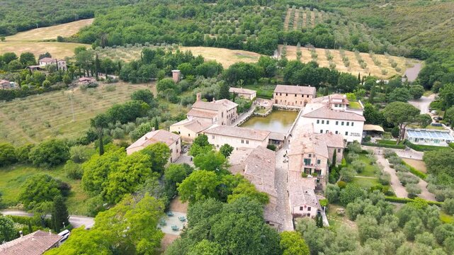 Bagno Vignoni natural pools along the city hill in Tuscany, view in spring season from drone