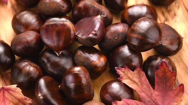 Chestnut, Fresh sweet chestnuts background, top view. Thanksgiving day. Edible chestnuts (Castanea sativa) pile over wood background, from above. 