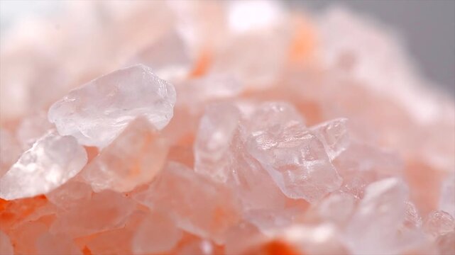 Himalayan pink salt background, Himalayan salt crystals close up. Pink coarse salt crystals macro shot, rotating backdrop.