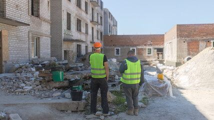 Fototapeta premium Construction Site Supervisors Overseeing Building Reconstruction Project
