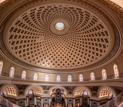 Wide lens photo of the interior of the church of St Mary, known as the Mosta Rotunda or Mosta Dome, Malta