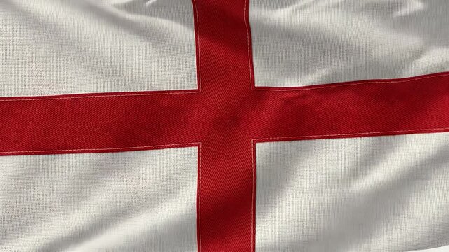 A detailed close-up of the flag of England, featuring a red cross on a white background. The flag billows gently, showcasing the texture of the fabric and the boldness of the red cross.