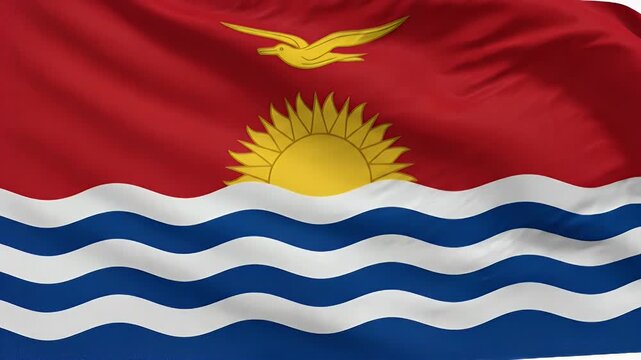 This video shows a close-up of the flag of Kiribati waving gently in the wind. The flag features a red background, with a golden frigatebird flying above a golden rising sun, which sits atop a blue