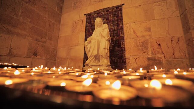 Small candles illuminating the image of the Virgin Mary with Jesus in Jerusalem, Israel