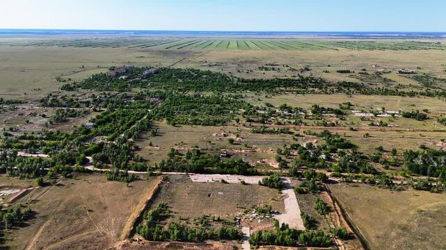 Drone footage of completely destroyed military airbase buildings in Chagan, overgrown with trees and wild grass. Territory of the Semipalatinsk Test Site, Kazakhstan. Nature reclaims the ruins 