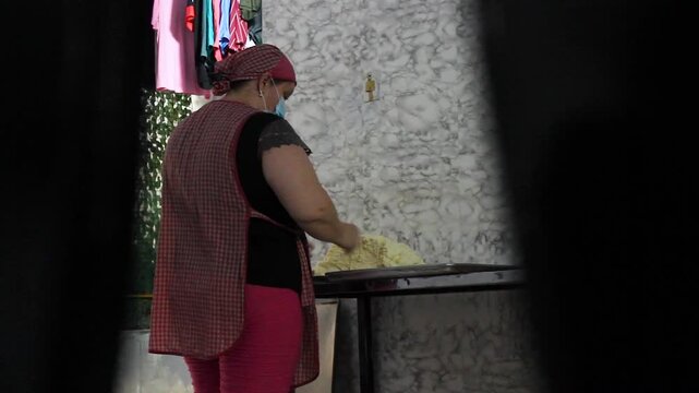 A young Hispanic woman is making achira biscuits by hand on a table inside her home in Yaguara, Huila, Colombia. Concept of handmade and copy space
