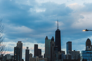 Fototapeta premium View of city skyline with tall buildings and clouds during evening hours in urban setting