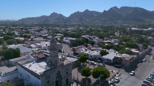The ornate white bell tower of the Nuestra Se&ntilde;ora del Carmen Parish Church in Hermosillo, Sonora (Mexico). In the background, the iconic Cerro de la Campana rises, its communication antennas visible.