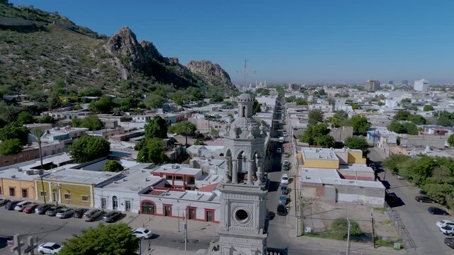 The ornate white bell tower of the Nuestra Se&ntilde;ora del Carmen Parish Church in Hermosillo, Sonora (Mexico). In the background, the iconic Cerro de la Campana rises, its communication antennas visible.