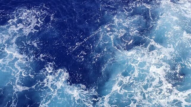 Oceanic expanse with turbulent waters and foamy patterns abounds view.