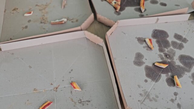 Leftover pizza boxes on the floor after a party in an apartment