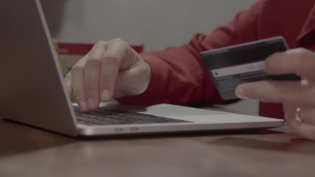 Woman using a laptop and credit card for online payment and internet banking, showcasing secure digital transactions and modern online shopping activity.