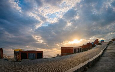 Obraz premium Dramatic sunset over residential urban street with cloudy sky