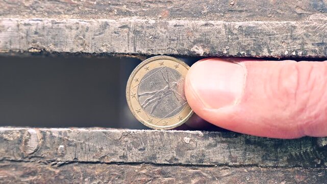 one euro coin placed inside a metal press while a hand slowly rotates it. The scene emphasizes metallic textures, industrial mechanics, and concepts related to currency, manufacturing, and precision 