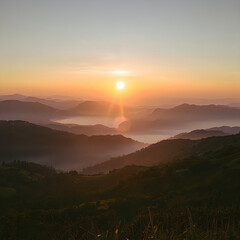 Obraz premium Breathtaking Sunrise Over Misty Mountains with Golden Hour Lighting