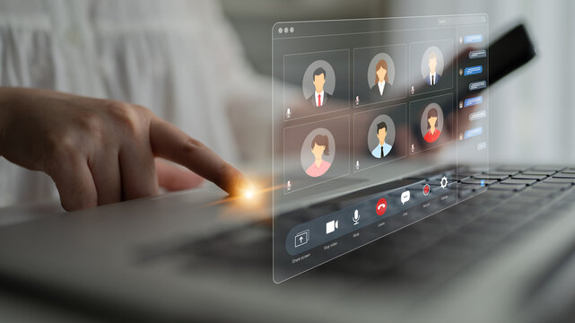 Virtual Meeting Interaction With Hand Touching Laptop Keyboard and Participants Displayed on Screen in Modern Workspace Setting. Bitwise.