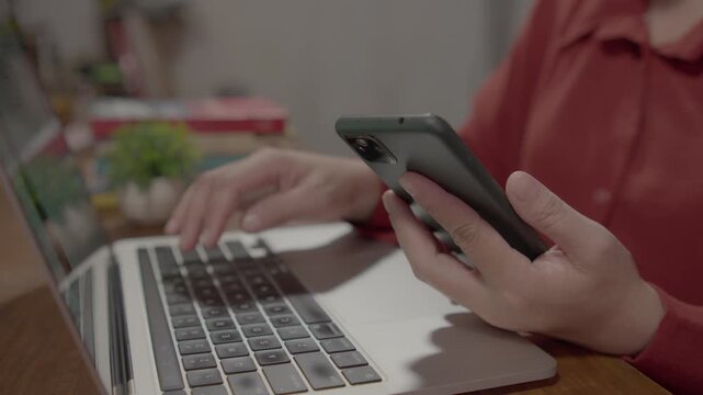 Close up of a businesswoman logging into an online account with smartphone verification and laptop computer, showcasing 2FA security, data protection, and secure digital access.