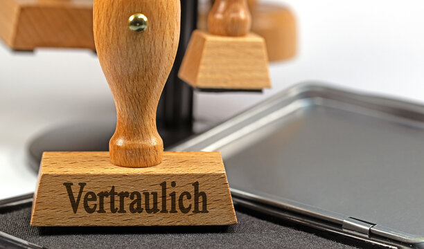 Holzstempel mit dem Text Vertraulich