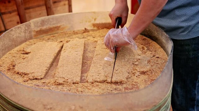 Chinese street food vendor cutting rice cake in Furong ancient town