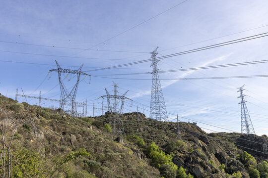 View of Aldeadavila II Electrical Substation with high-voltage transmission towers and power lines on a rocky hillside under a clear sky in Aldeadavila de la Ribera, Castile and Leon, Spain.