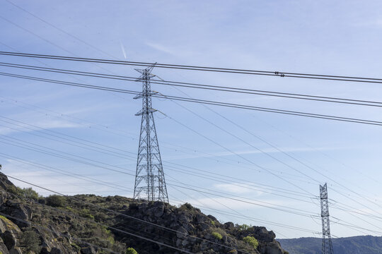 View of high-voltage power lines and transmission towers at the Aldeadavila II Electrical Substation on a rocky hillside under a clear blue sky Aldeadavila de la Ribera, Castile and Leon, Spain.