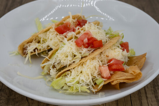 Hearty plate of hard shell tacos smothered in lettuce, cheese, and pico to satisfy that urge for a Mexican food meal