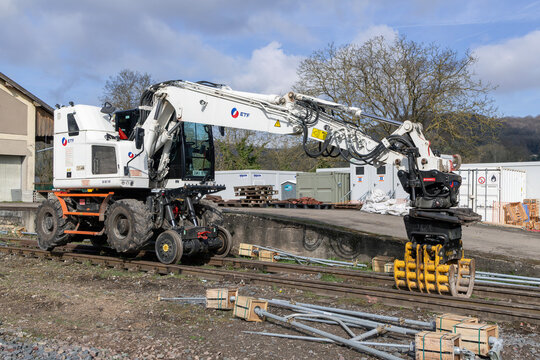 Onville, France - March 15th 2026 : View on a white road-rail wheeled excavator CAT M323F on a construction site for the renovation of a railway line.