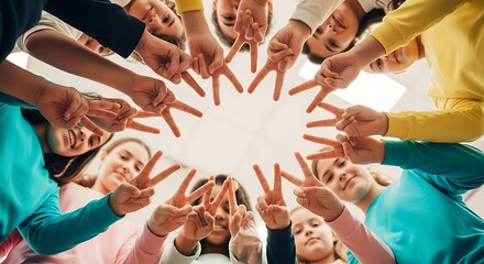 Obraz premium A diverse group of individuals creates a unified circle by raising their hands in peace signs against a plain background.