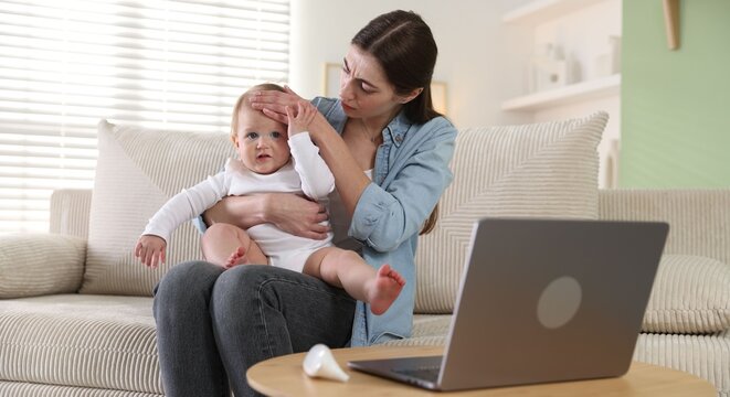 Telemedicine. Mother and her baby having online consultation with doctor via laptop at home