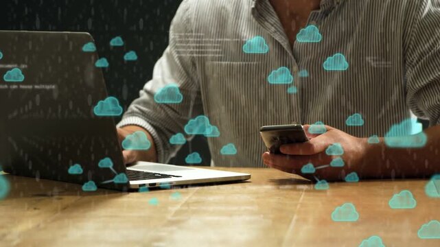 Man tapping smartphone and typing laptop, spawning cloud icons linking to tech syncing cloud data