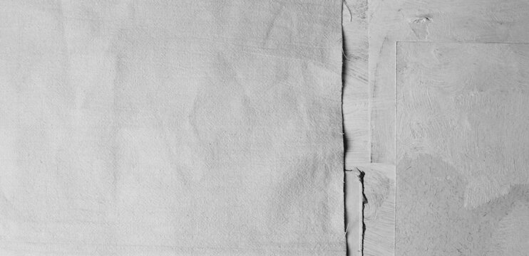Torn, ripped blot crack crumble frame paper canvas; fabric pieces. Gray, beige white copy space grunge relief grain texture poster wall background.
