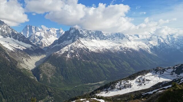 Young woman celebrating on a mountain summit above the Chamonix valley in the French Alps, filmed in cinematic slow motion