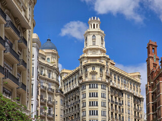 Obraz premium Wide view of Plaza del Ayuntamiento in Valencia, Spain, with pedestrians strolling between ornate buildings. The scene shows Valencia central square and architecture.