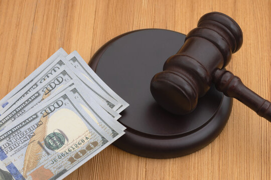 Judge gavel and block with money on wood desk