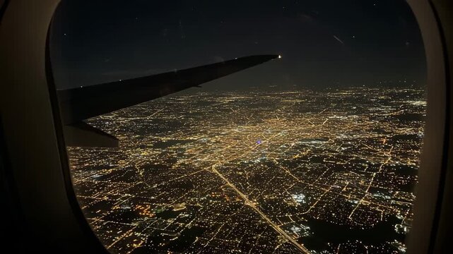 Aerial view of city lights at night from airplane window  