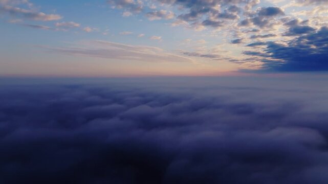 Drone Camera Tilting above foggy cloud layer revealing horizon and soft tones