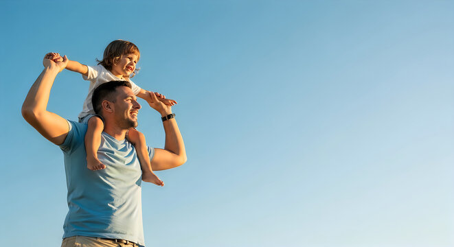 father carrying son on shoulders outdoors