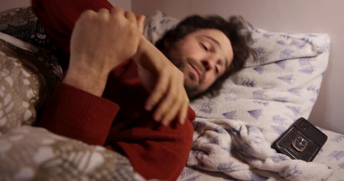 Man watching tv with remote control falls asleep in bed