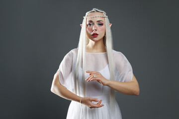 Naklejka premium Beautiful girl dressed as elf on grey background