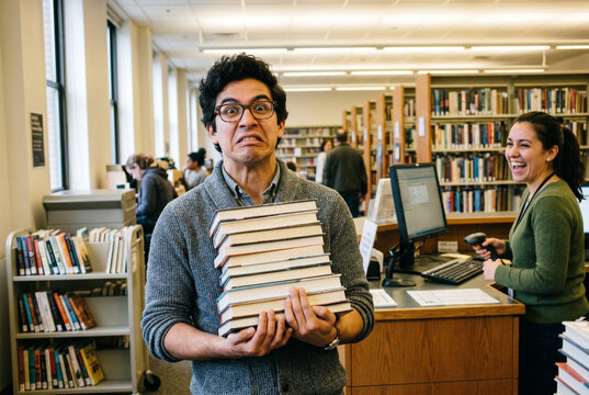 Librarian Dramatically Pretending Returned Books Are Incredibly Heavy