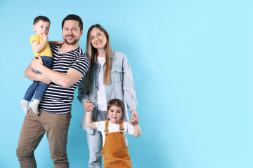 Fototapeta premium Portrait of happy family on light blue background, space for text