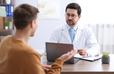 Fototapeta premium Man having appointment with doctor in clinic, selective focus