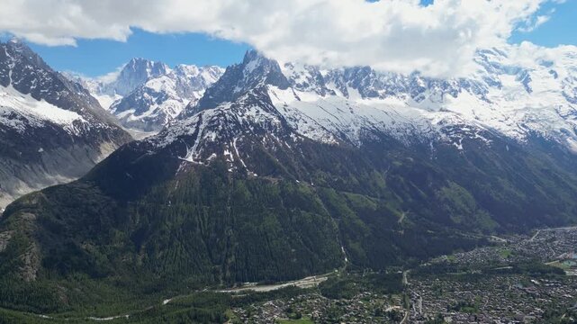 Wide cinematic drone panorama of the Mer de Glace glacier surrounded by dramatic snowy peaks and alpine landscapes in the Chamonix valley, France, captured from above in the heart of the French Alps.