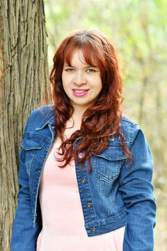 Mujer Guatemalteca recostada en el tronco de un &aacute;rbol, cabello casta&ntilde;o chaqueta azul y blusa rosada. Chica bonita.