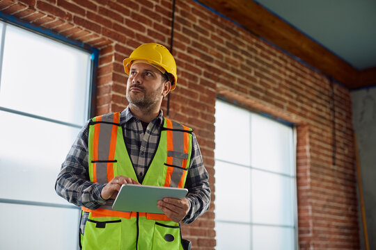 Construction worker using touchpad while working on home renovating project.