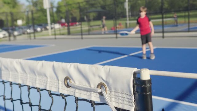Happy Children Playing Pickleball Game Hitting, Pickleball Yellow Ball With Paddle, Outdoor Sport Leisure Kids Activity. Athletic Child Hits Ball With Pickleball Racket. Outdoor Sport Leisure Activity