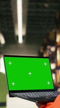Vertical Video Chroma key screen with black worker operating packages and cargo in warehouse facility, operational workflow and shipping activity assures order fulfillment operations for manual labor.