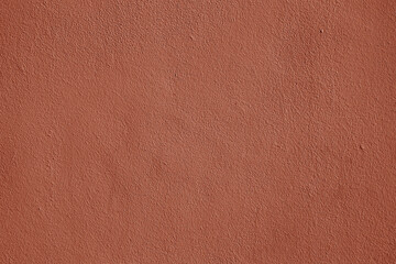 Fototapeta premium Coral stucco wall texture, peach fuzz color background. Abstract grunge artistic backdrop for design. Salmon color ribbed paper, pastel pink plaster, pattern.