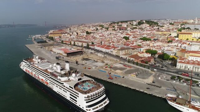 Cruise boat on the banks of the Tejo River with the historic city of Lisbon in the background.