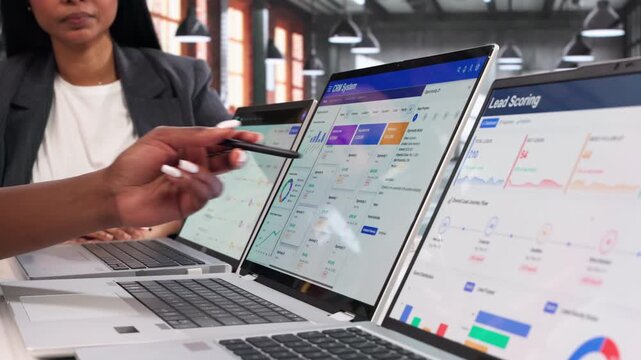 Two Women Discussing CRM Software On Laptop
